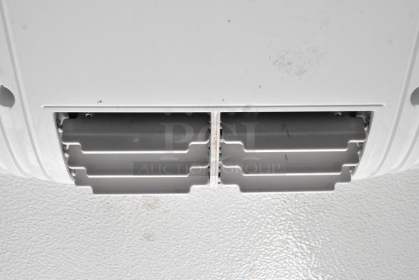 Ventilation grille in a cold food/beverage trailer, showing clean slots and minor surface marks.