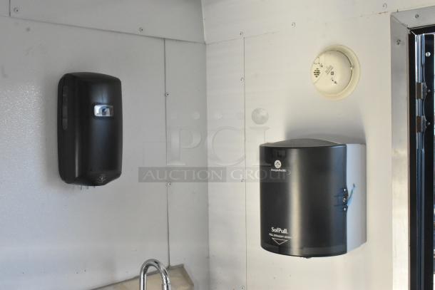 Inside a 2021 unbranded food trailer, black Georgia-Pacific soap dispenser, SofPull paper towel holder, sleek interior.