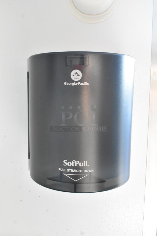 Georgia-Pacific SofPull paper towel dispenser, black, wall-mounted. Features pull-down mechanism. Suitable for commercial use.