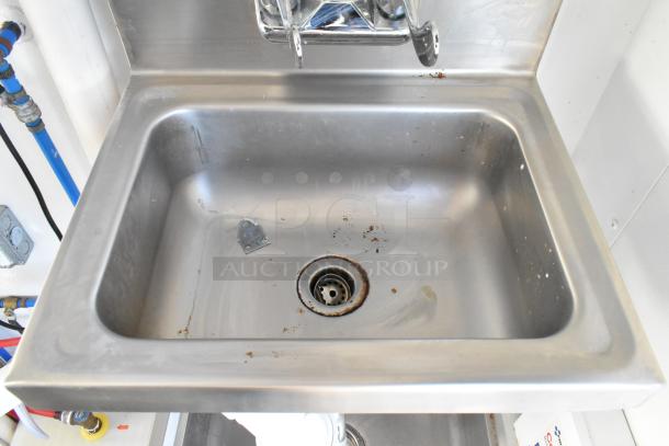 Stainless steel sink with minor rust at the drain, part of a cold food & beverage trailer setup.