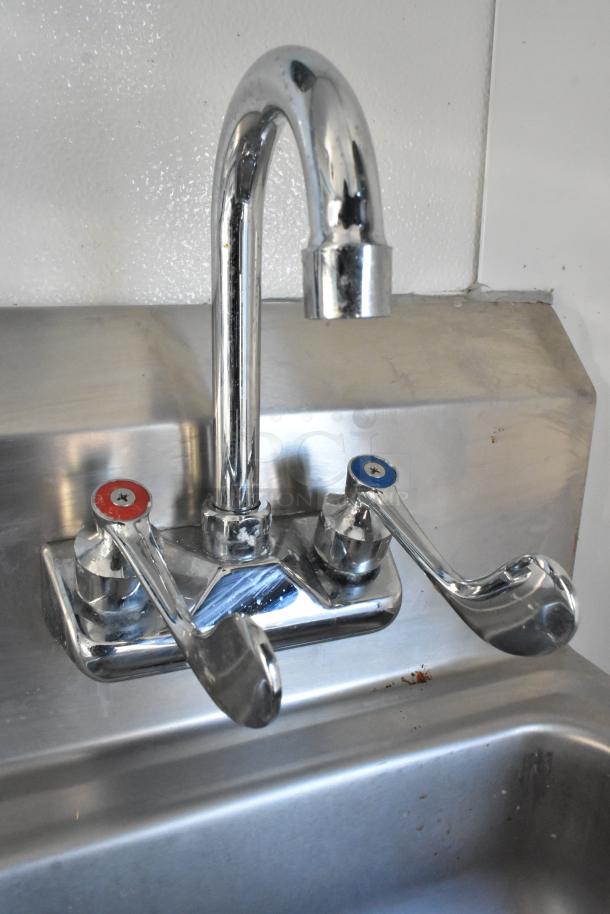 Stainless steel sink with dual-handle chrome faucet in a cold food and beverage trailer. New and fully equipped.