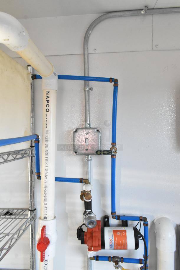 Cold food & beverage trailer interior showing plumbing and electrical fixtures, including pipes and a SEAFLO pump.