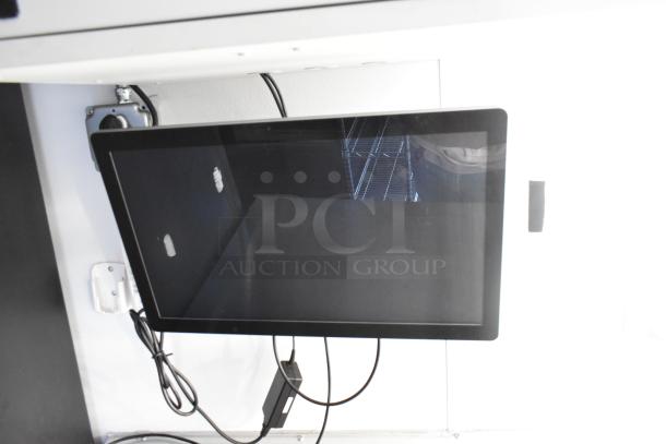 Unbranded cold food & beverage trailer interior, featuring mounted display screen. Includes wiring and stainless steel shelving.