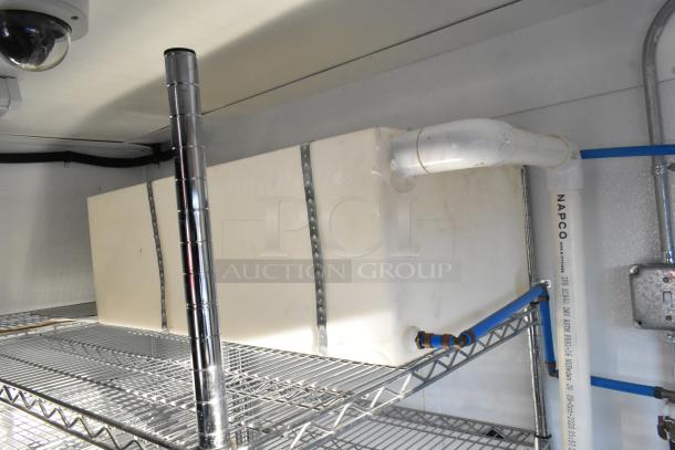 Interior view of unbranded 2021 cold food and beverage trailer. Features NAPCO piping, metal shelving, and commercial fittings.
