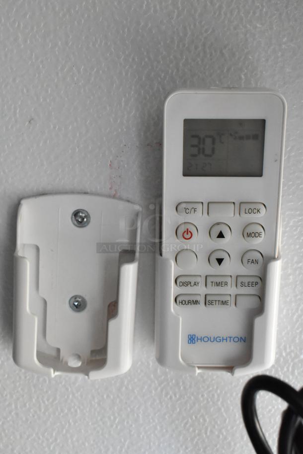 White remote control with digital display showing temperature, wall-mounted holder, labeled "Houghton."