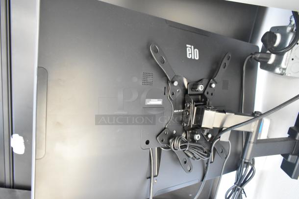 Rear view of a mounted Elo touchscreen monitor, showing mounting hardware and cable connections.