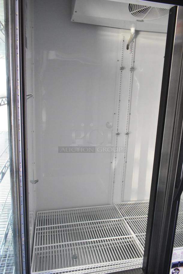 Interior view of a commercial-grade cooler in an unbranded retail trailer. Features wire shelving and bright lighting.