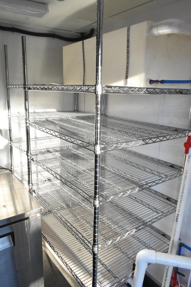 Chrome wire shelving in a new unbranded cold food and beverage retail trailer. Includes plumbing, stainless steel equipment.
