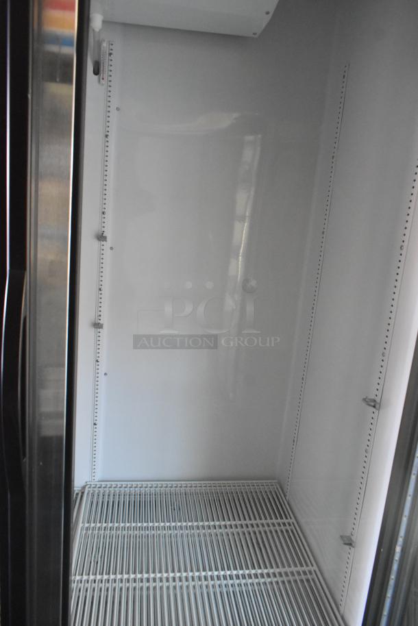 Interior of a commercial-grade True cooler merchandiser with white shelving, ready for use in a retail trailer.