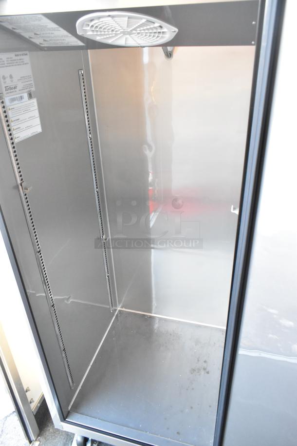 Interior of a Turbo Air commercial cooler in excellent condition, showcasing clean shelves and clear labels inside.