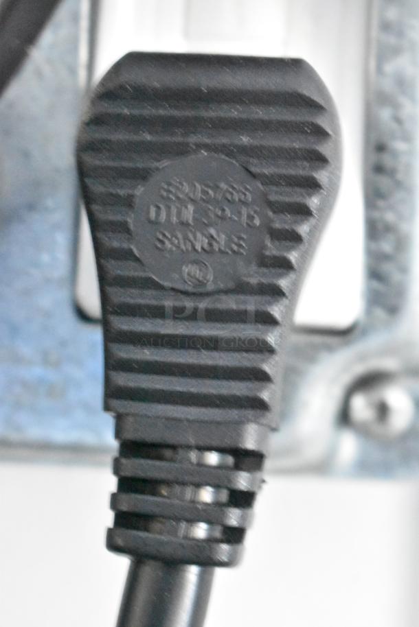 Close-up of a black electrical plug with the markings "SB-5793", "D1L-2-15", and "SA" visible.