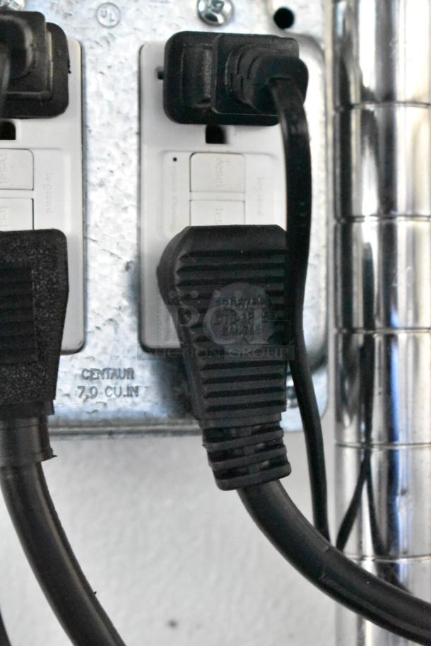 Close-up of electrical outlets and plugs in a retail trailer, featuring a "CENTAUR 7.0 CU. IN." marking on the metal panel.