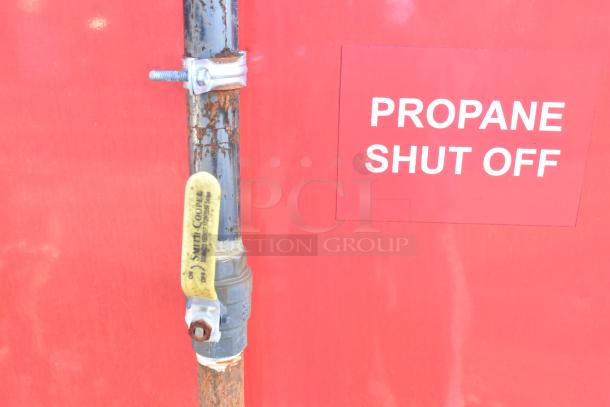 Red panel with a propane shut-off valve labeled "Smith Cooper" and a sign reading "PROPANE SHUT OFF" on Titanium Cargo 28' trailer.