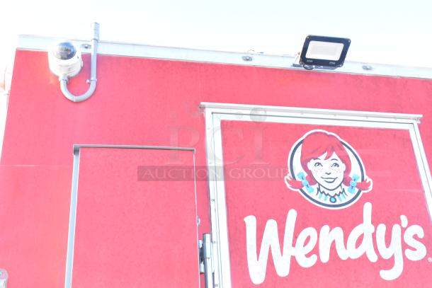 Red food trailer by Titanium Cargo featuring a security camera and Wendy's logo. Ready to be outfitted with equipment. Sold with clear title.