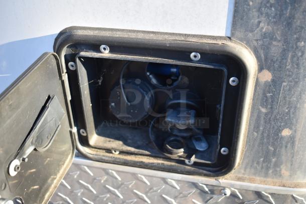 Fuel access panel on Nationwide 24' food trailer, highlighting entry for utilities. Features diamond plate flooring.