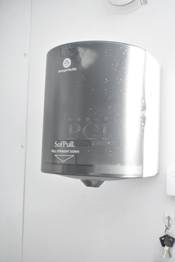 Georgia-Pacific SofPull paper towel dispenser mounted on a wall with keys hanging nearby.