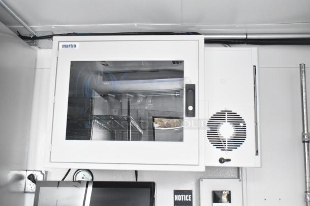 Unbranded cold food and beverage trailer interior with a Martin control panel, commercial shelves, and equipment visible.