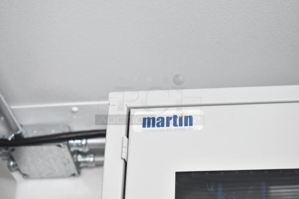 Close-up of Martin International Enclosures, Inc. label inside the unbranded retail trailer, highlighting the equipped interior.