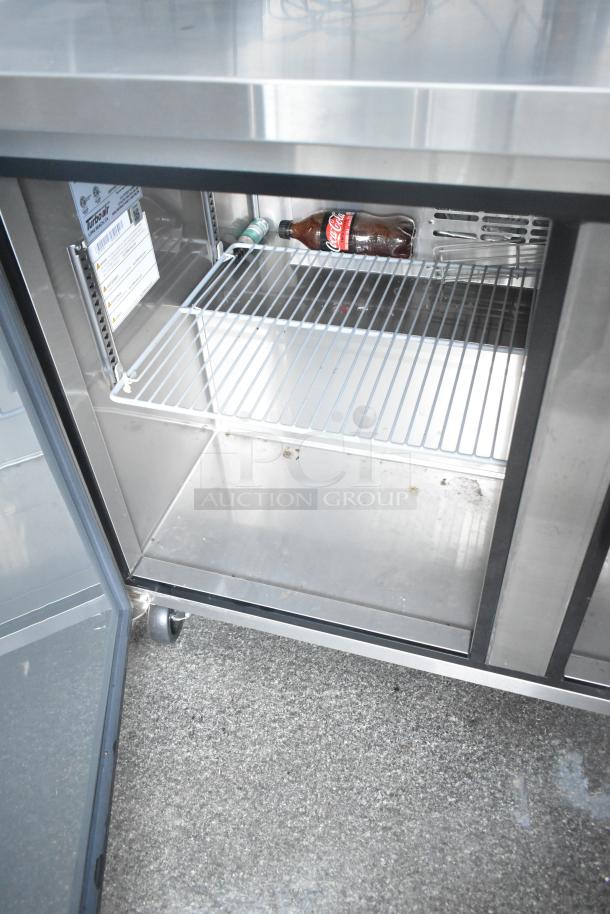 Turbo Air cooler interior in new cold food and beverage trailer. Includes shelving, open door, with visible label and empty space.