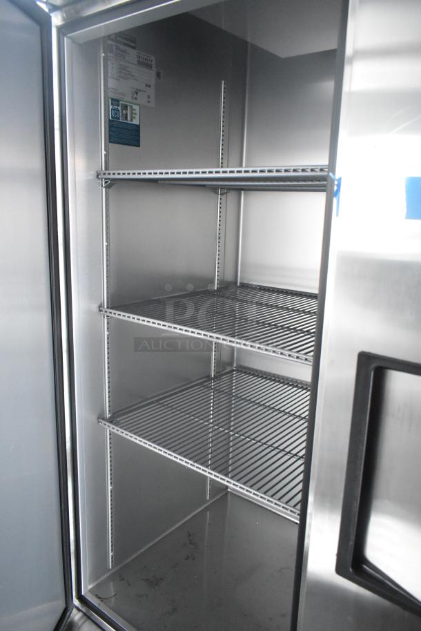 Commercial-grade True cooler interior with three metal shelves inside a 2021 outfitted cold food and beverage trailer.