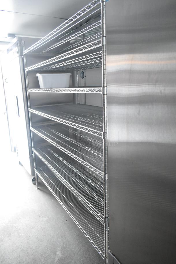 Interior of a fully outfitted retail trailer showing metal shelving near commercial-grade equipment and stainless steel surfaces.
