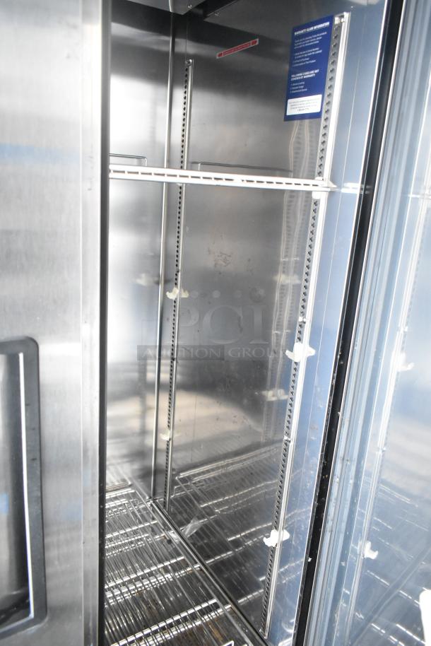 Interior of a commercial-grade cooler in an unbranded food and beverage trailer, showcasing shelves and stainless steel details.