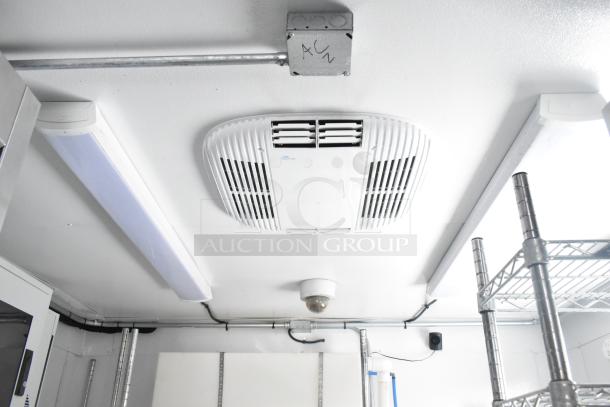 Interior view of a 2021 unbranded cold food and beverage trailer. Features ceiling-mounted air conditioning system and shelving.