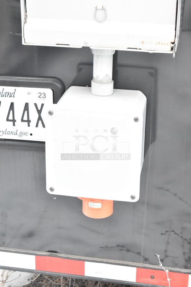 Close-up of a utility connection on the underside of a cold food and beverage trailer. Features a clear title license plate.