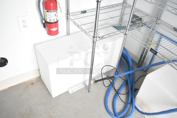 Brand new Nationwide 24' shell food trailer interior with shelving, fire extinguisher, and infrastructure for a custom kitchen.