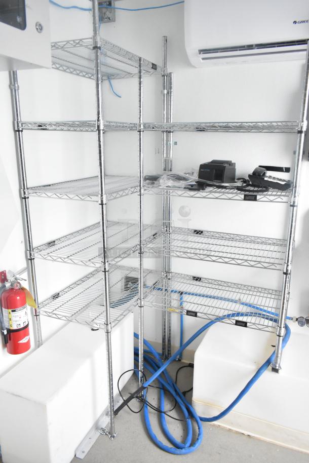 Brand new Nationwide 24' shell food trailer interior with metal shelving, Gree AC, fire extinguisher, and plumbing infrastructure.