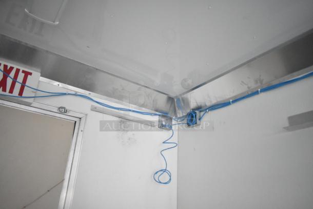 Interior view of a Nationwide 24' shell food trailer showing installed blue wiring, exit sign, and metal trim.