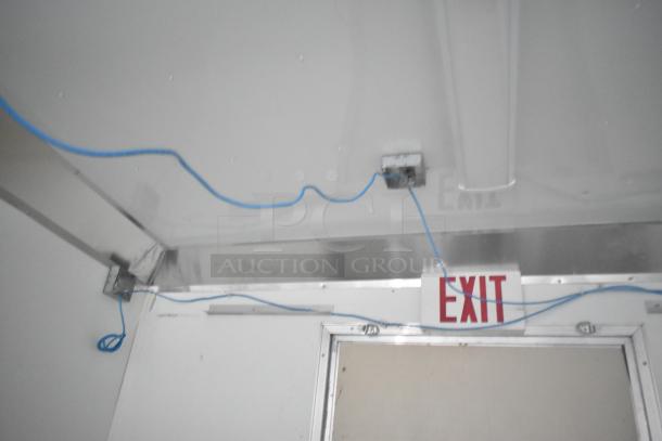 Interior view of a Nationwide 24' food trailer shell, featuring electrical wiring and an overhead EXIT sign.