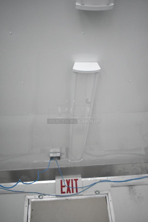 Brand new 24' Nationwide shell food trailer with versatile interior, Gree AC, sinks, shelving, and exit sign. Ready for customization.