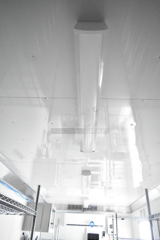 Interior of a brand new 2021 Nationwide 24' shell food trailer. Features include Gree AC, sinks, and shelving. Ready for customization.