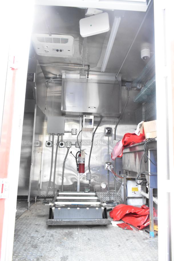 Brand new 28' Titanium Cargo mobile kitchen trailer, equipped with grease hood, sinks, shelving, and security system.