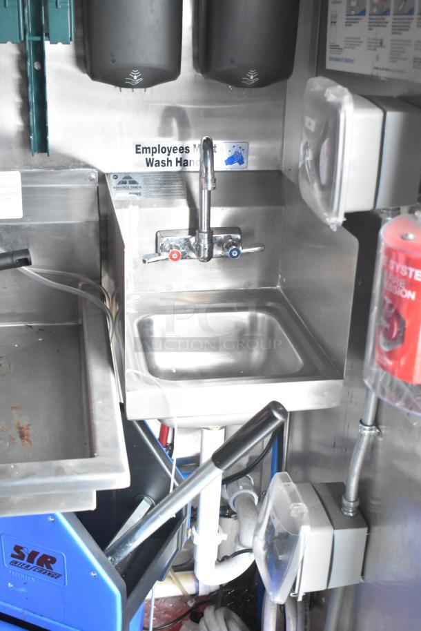 Inside view of a new 2021 Titanium Cargo 28' food trailer. Features a stainless steel sink, grease hood, and integrated security system.