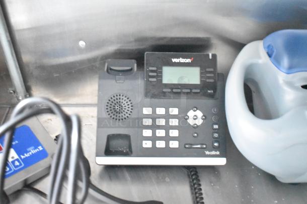 Telephone and cleaning supplies inside the Titanium Cargo 28' mobile kitchen trailer.