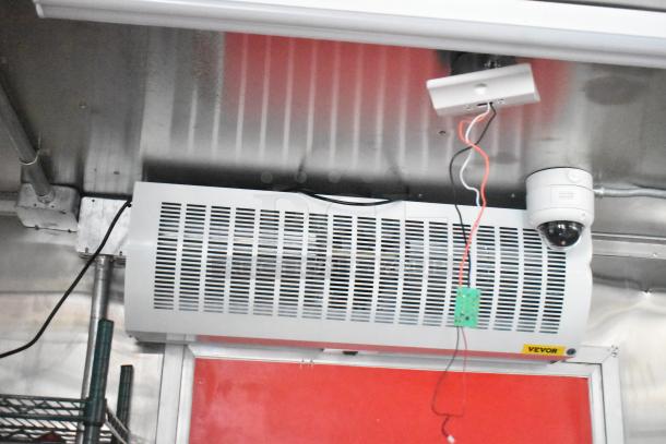 Interior view of 2021 Titanium Cargo 28' food trailer featuring grease hood, security camera, and wiring for customization.