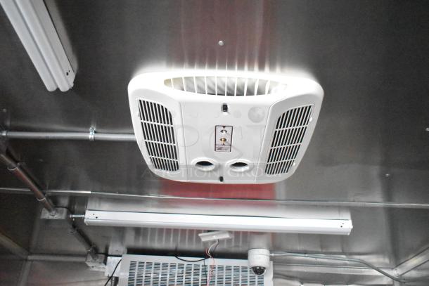 Interior view of a 2021 Titanium Cargo 28' mobile kitchen trailer showing installed ventilation and security system.