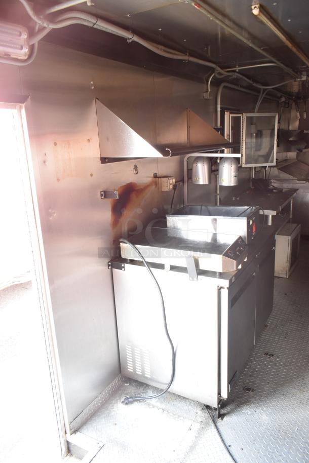 Interior of 2020 Continental Cargo 8.5' x 28' mobile kitchen trailer, featuring a stainless steel cooking line and hood system.