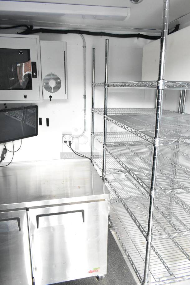 2021 Southern Dimensions enclosed trailer interior with metal shelving, stainless steel counter, refrigeration unit, and clean condition.