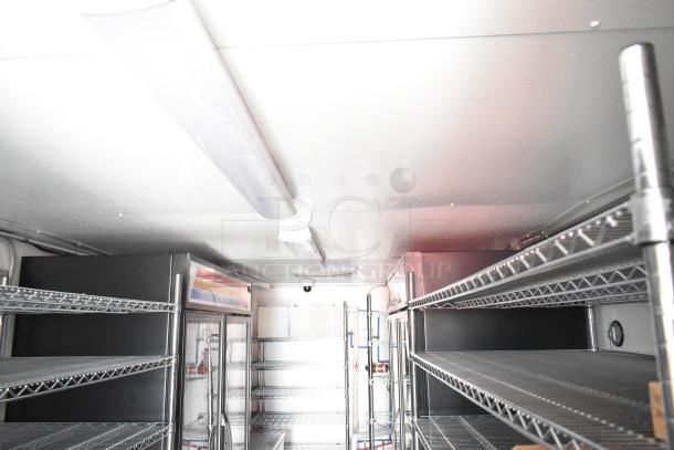 Interior of 2021 Southern Dimensions Group 8.5' x 24' food trailer with commercial coolers, freezers, and shelving.