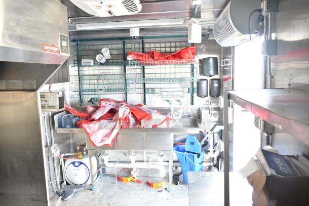 2021 Titanium Cargo 8.5' x 28' mobile kitchen trailer interior, CaptiveAire 7'7" grease hood, 3-bay sink, plumbing.