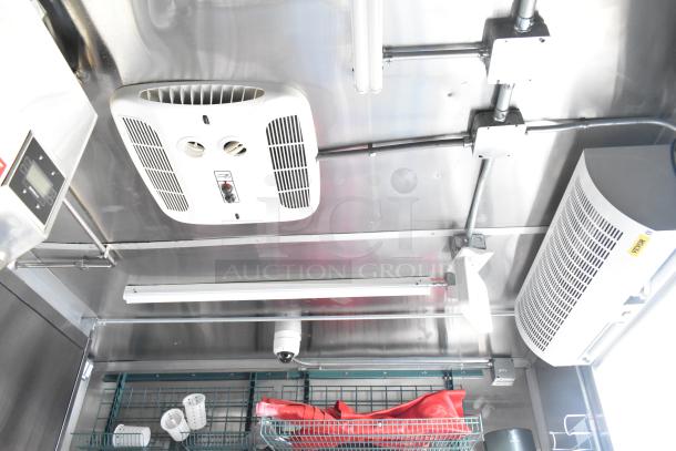 Interior view of 2021 Titanium Cargo mobile kitchen trailer showing the Coleman Mach A/C unit and electrical and plumbing setup.