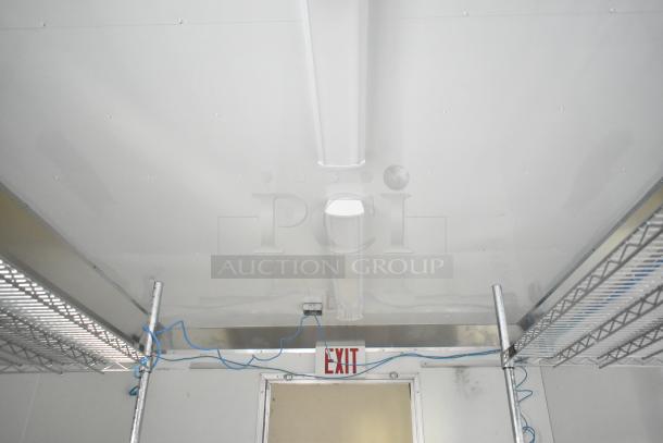 Interior view of a 2021 Diamond Cargo 8.5' x 24' trailer, featuring Metro shelving, LED lights, and an exit sign.