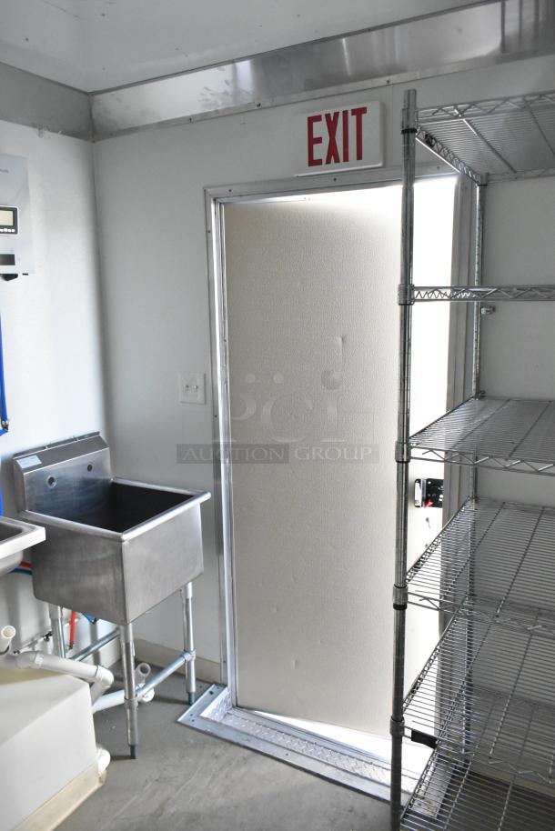 2021 Diamond Cargo 8.5' x 24' trailer interior with stainless steel sink, wire shelving, and an "EXIT" sign above the door.