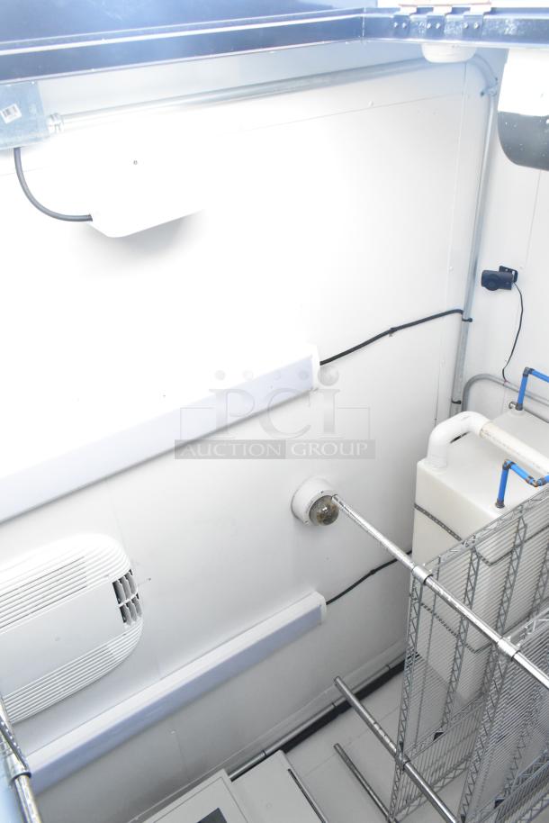 Interior of 2021 Southern Dimensions mobile cold storage trailer, featuring shelving, piping, and cooling system. Near-new condition.