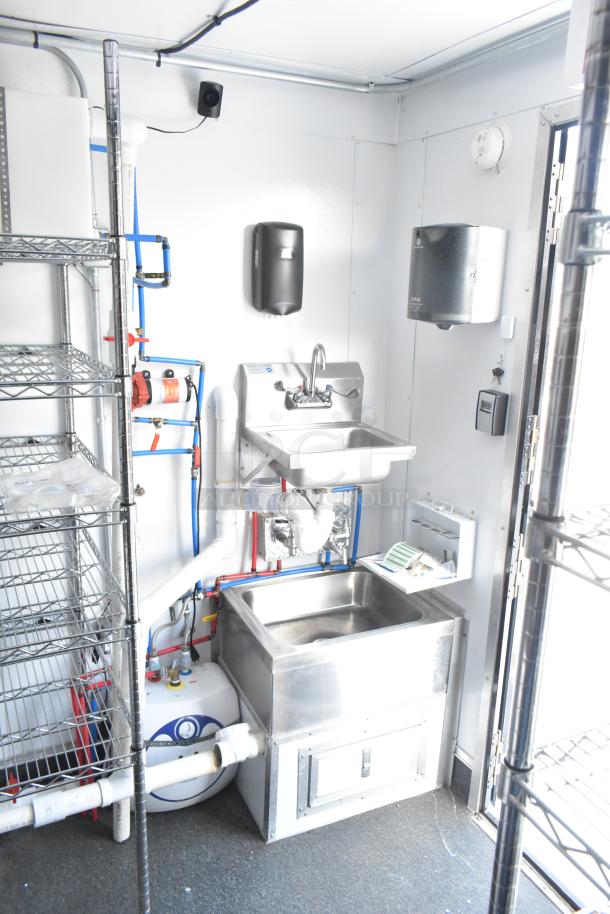 2021 Southern Dimensions trailer interior showing self-contained water station, metal shelves, and utility hooks. Near-new condition.