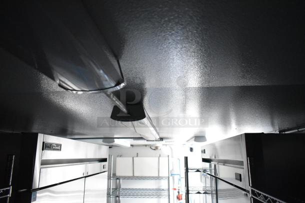 Interior of 2021 Southern Dimensions mobile cold storage trailer showing True reach-in coolers, shelving, and lighting.