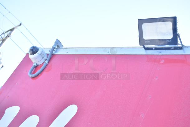 Red mobile kitchen trailer by Rock Solid Cargo, featuring security camera and 50W IP66 light. Part of Wendy's-style fast-food setup.